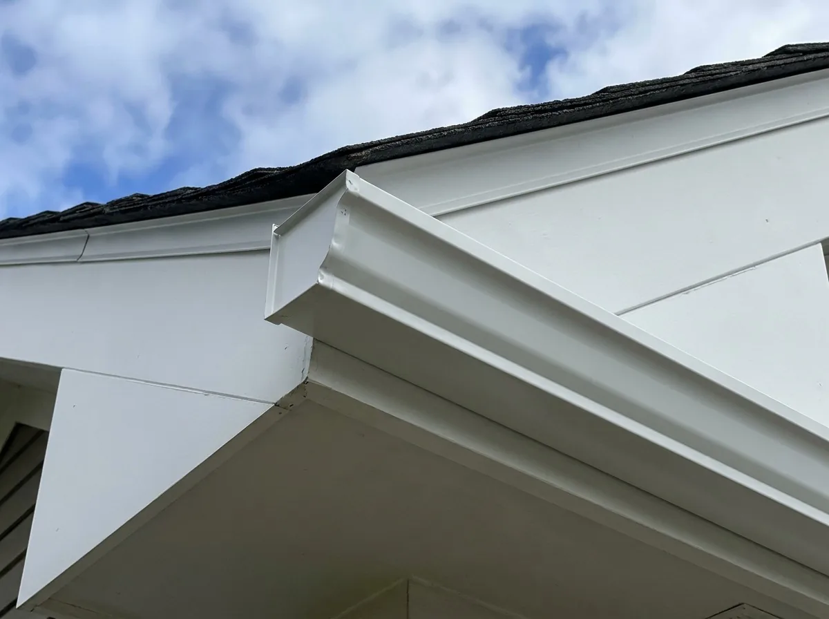 White seamless gutter along fascia under a clear Minnesota sky