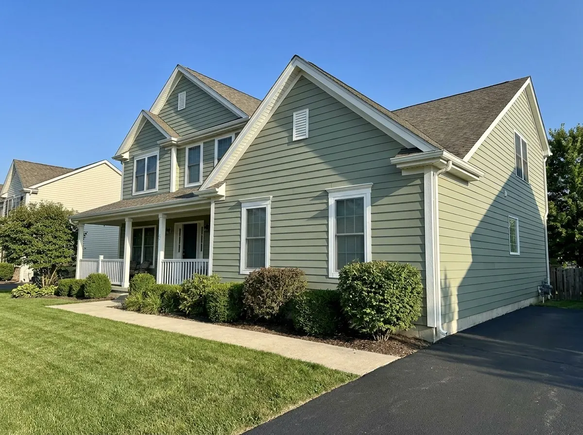 Two-story home with sage green lap siding and white trim in Minneapolis, MN